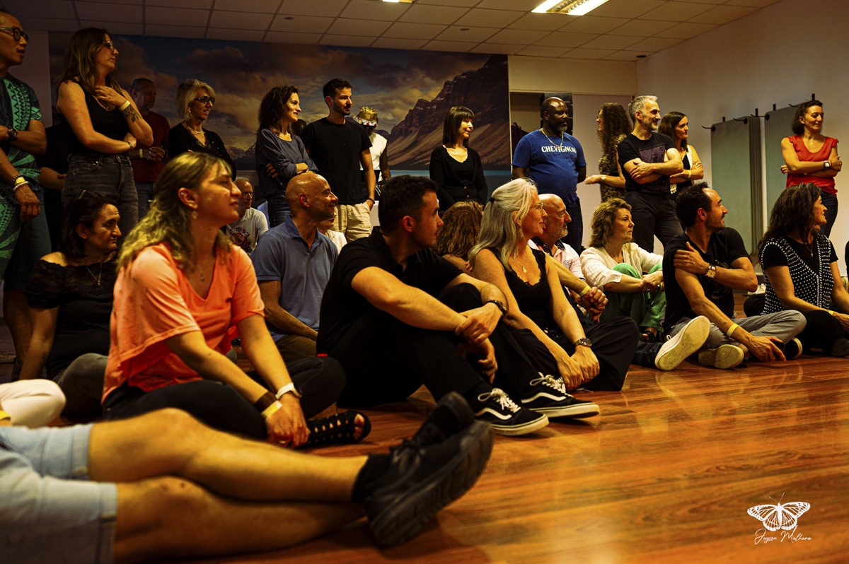 Groupe attentif sur parquet lors d'un atelier. Logo Jayson Mahana et t-shirt Chevignon présents.